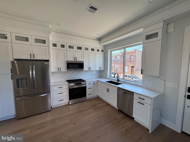 3003 Gaul St, Philadelphia, PA 19134 - kitchen with a sink, white cabinetry, visible vents, appliances with stainless steel finishes, and tasteful backsplash
