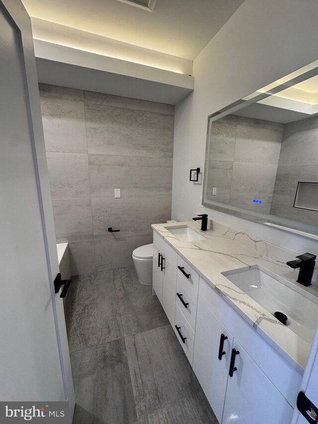 3003 Gaul St, Philadelphia, PA 19134 - bathroom featuring a sink, double vanity, toilet, and wood finished floors
