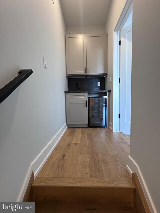 3003 Gaul St, Philadelphia, PA 19134 - bar with a bar, beverage cooler, a sink, light wood-style floors, and tasteful backsplash