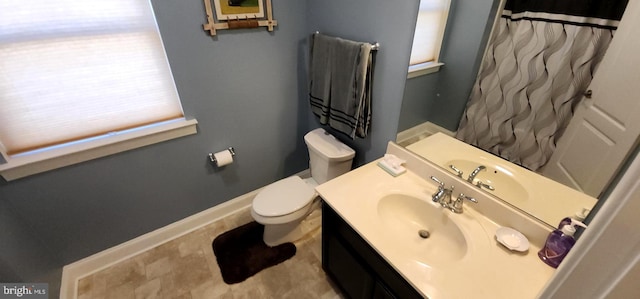 bathroom featuring toilet, vanity, and a shower with shower curtain