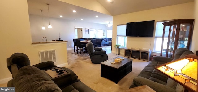 carpeted living room featuring vaulted ceiling, ceiling fan, and plenty of natural light