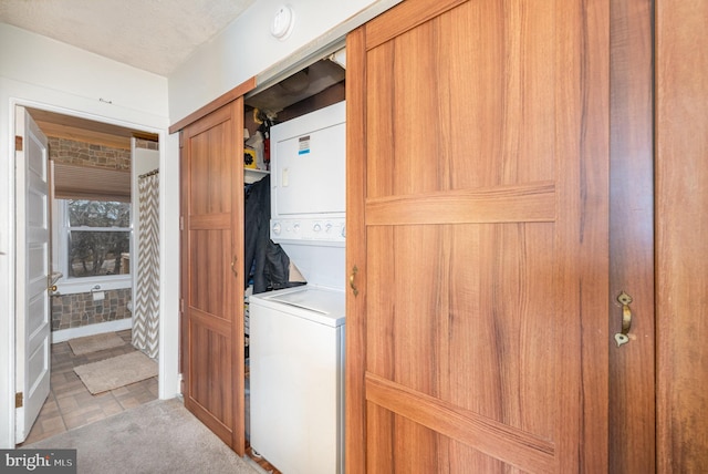 laundry area with stacked washer and clothes dryer and carpet flooring