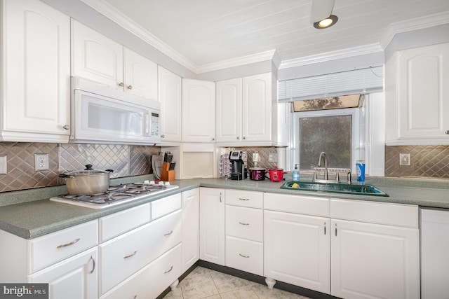 kitchen with light tile patterned flooring, stainless steel gas stovetop, white cabinetry, sink, and ornamental molding