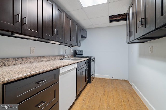 kitchen with a paneled ceiling, white dishwasher, black stove, sink, and dark brown cabinets