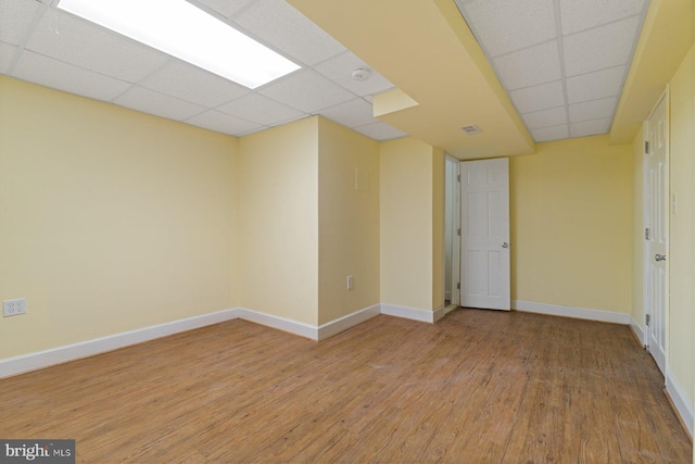 unfurnished room featuring light hardwood / wood-style floors and a drop ceiling