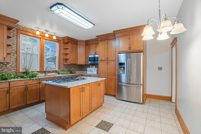 kitchen with appliances with stainless steel finishes, backsplash, sink, pendant lighting, and a notable chandelier