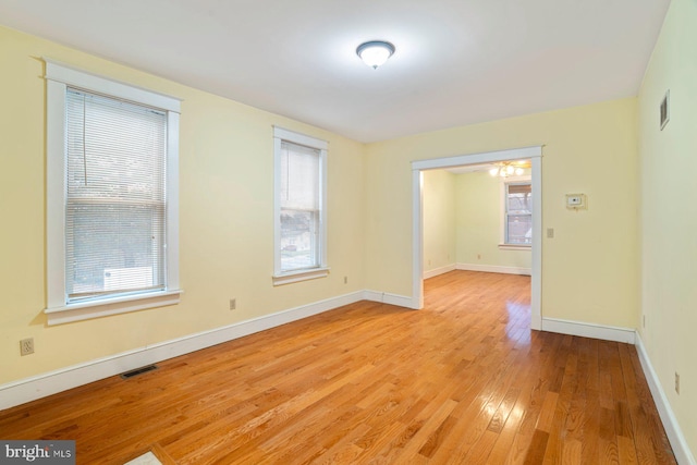 spare room with ceiling fan, a healthy amount of sunlight, and light hardwood / wood-style flooring