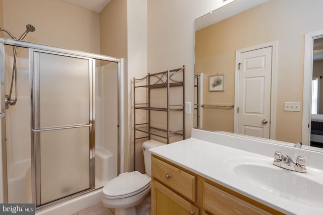 bathroom featuring a shower with door, vanity, and toilet