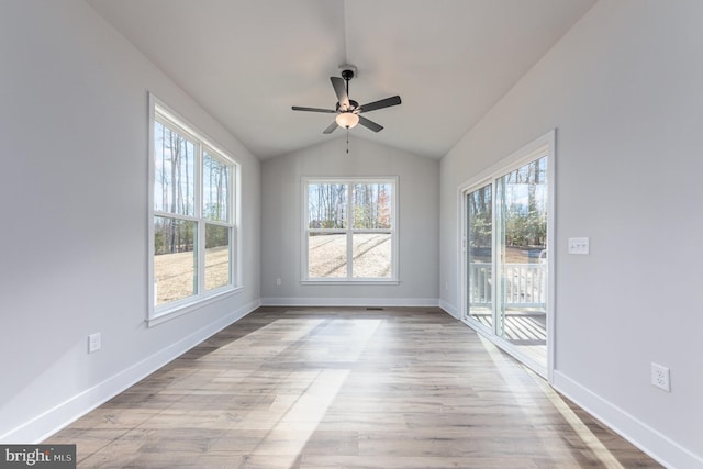 empty room with ceiling fan, light hardwood / wood-style flooring, and vaulted ceiling