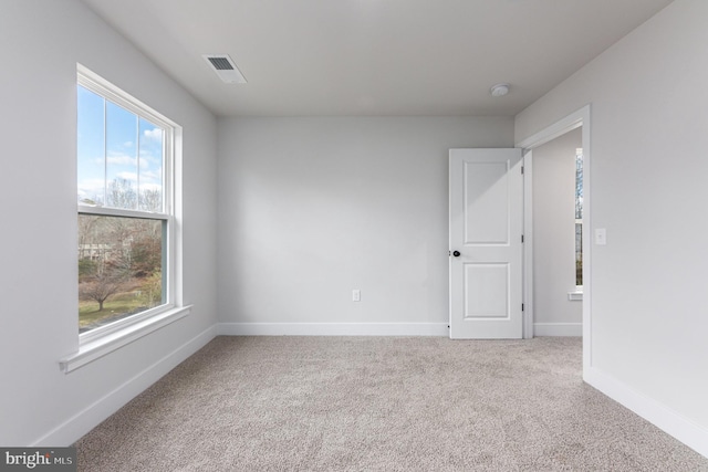 carpeted empty room with a healthy amount of sunlight