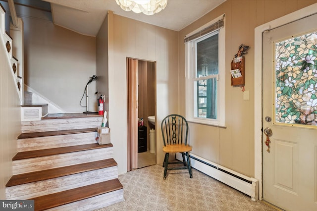 interior space with baseboard heating, light colored carpet, wooden walls, and a wealth of natural light