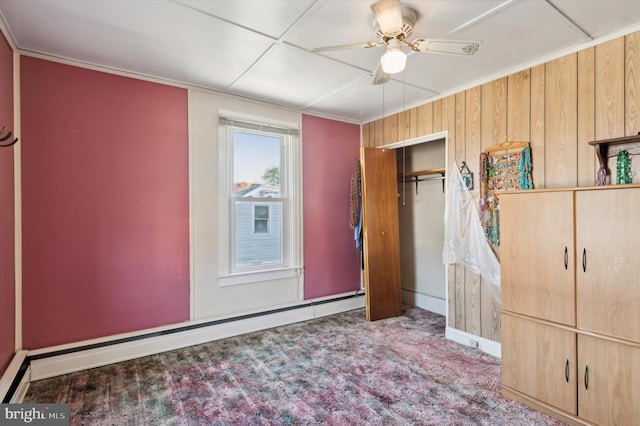 unfurnished bedroom with a baseboard heating unit, carpet floors, a closet, ceiling fan, and ornamental molding