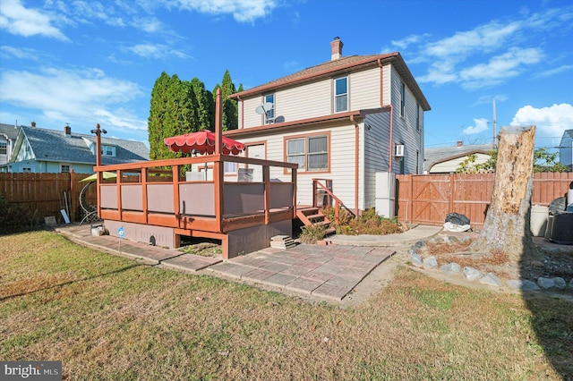 rear view of house featuring a patio, a deck, and a lawn