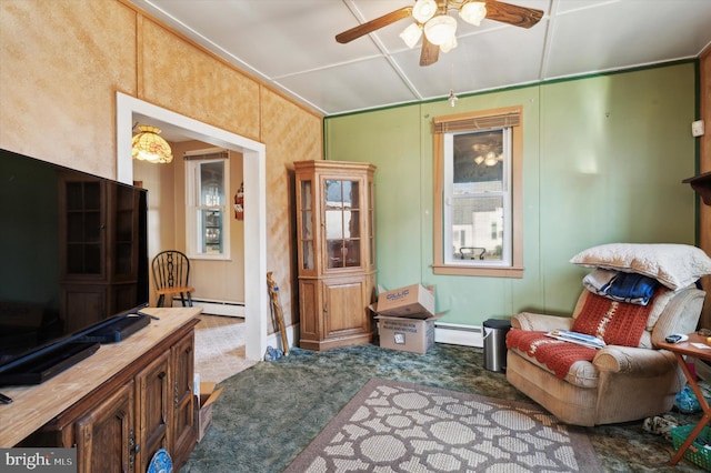 sitting room featuring ceiling fan, a baseboard radiator, and dark colored carpet