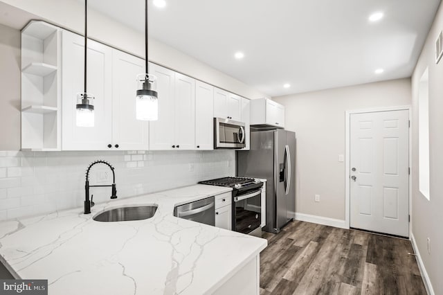 kitchen featuring light stone countertops, sink, stainless steel appliances, decorative light fixtures, and white cabinets