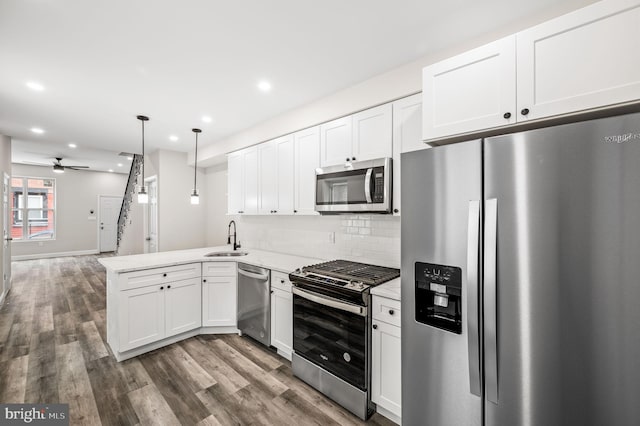 2442 Nicholas St, Philadelphia, PA 19121 - kitchen featuring a peninsula, a sink, dark wood finished floors, ceiling fan, and appliances with stainless steel finishes