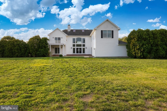 back of property featuring a patio, a yard, and a balcony