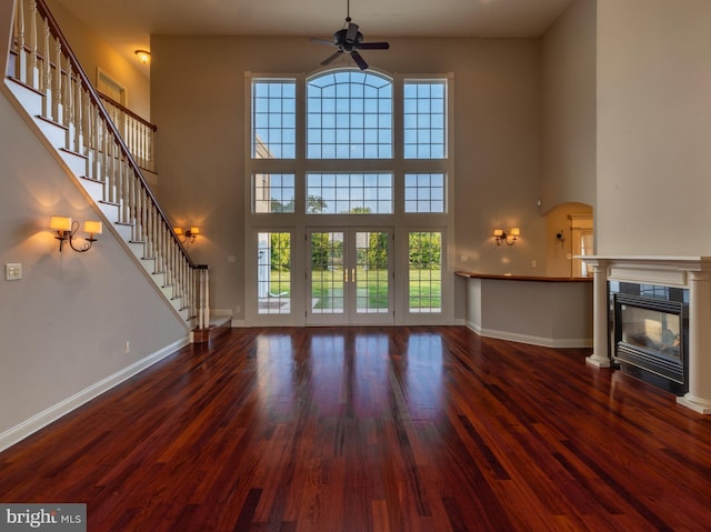 unfurnished living room featuring hardwood / wood-style flooring, a high ceiling, and plenty of natural light