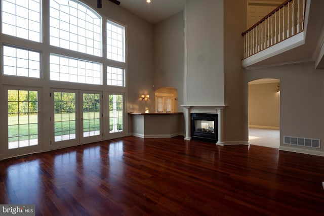 unfurnished living room featuring hardwood / wood-style floors and a high ceiling