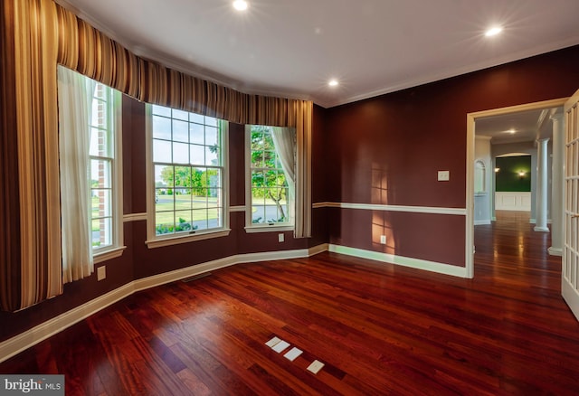 empty room with dark hardwood / wood-style flooring and ornamental molding