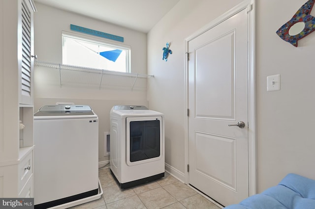 washroom with washing machine and dryer and light tile patterned floors