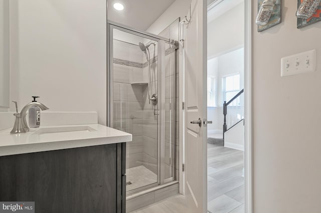 bathroom featuring wood-type flooring, vanity, and an enclosed shower