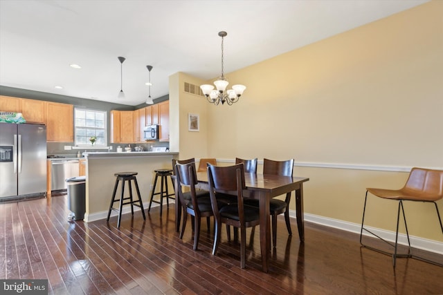 dining room featuring dark hardwood / wood-style flooring and an inviting chandelier