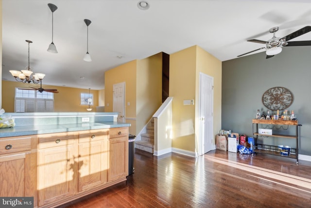 kitchen featuring ceiling fan with notable chandelier, dark hardwood / wood-style flooring, light brown cabinetry, and decorative light fixtures