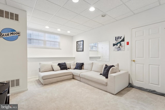 living room with a drop ceiling and carpet floors