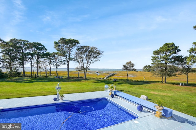 view of swimming pool with a lawn