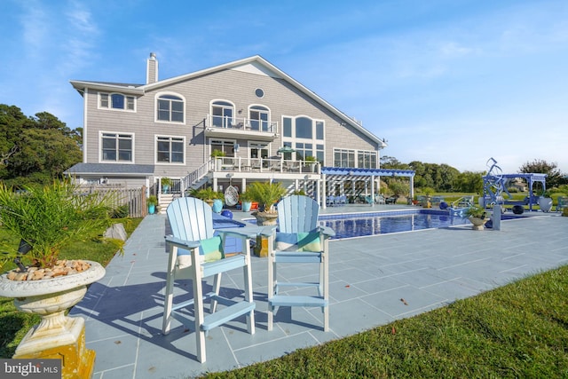 11209 Woodside Dr, Berlin, MD 21811 - rear view of house with a pergola, a patio area, a chimney, and an outdoor pool