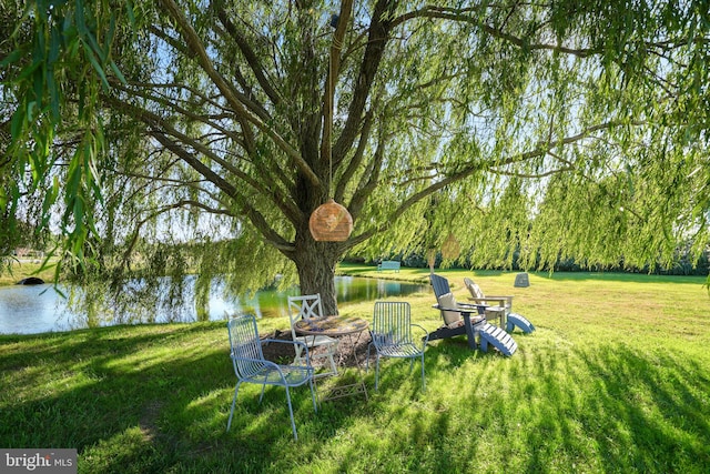 view of yard featuring a water view and an outdoor fire pit