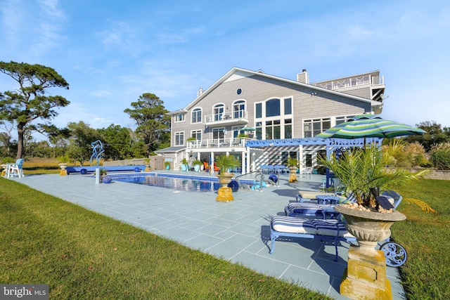 view of pool featuring a lawn and a patio