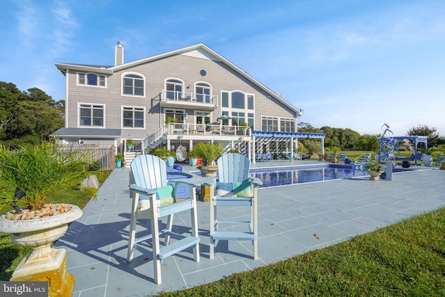 back of property with a balcony and a patio area