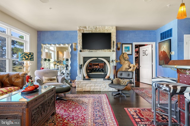 11209 Woodside Dr, Berlin, MD 21811 - living room featuring visible vents, wood finished floors, and a stone fireplace