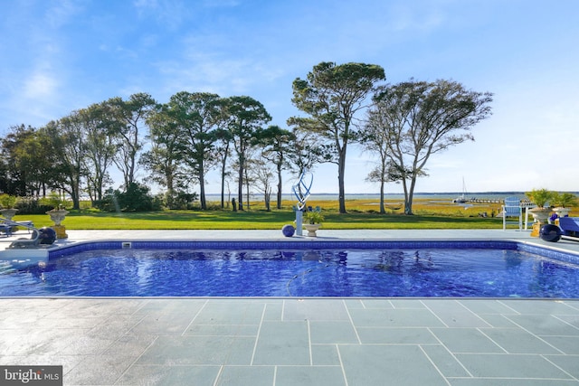 view of swimming pool featuring a yard