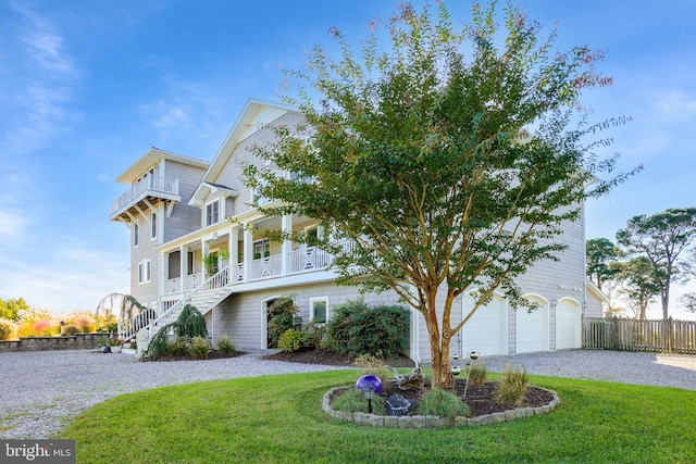 view of front of home featuring a porch, a garage, and a front lawn