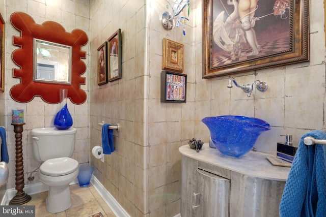 bathroom with tile patterned flooring, tile walls, and toilet