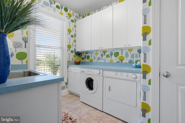 clothes washing area with cabinets and separate washer and dryer