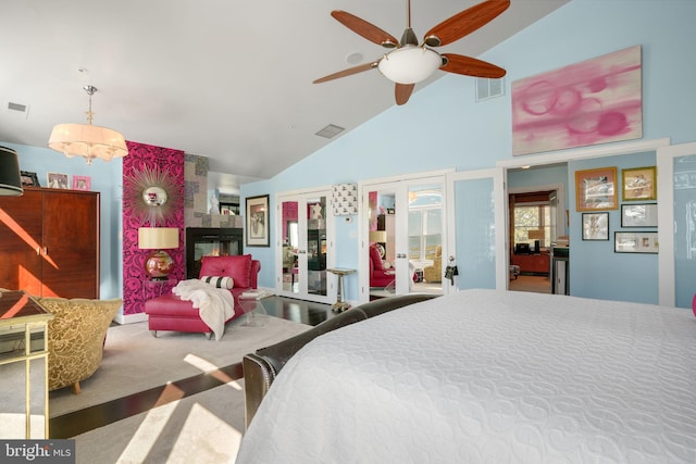 carpeted bedroom with high vaulted ceiling and ceiling fan with notable chandelier