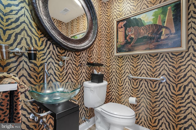 11209 Woodside Dr, Berlin, MD 21811 - half bathroom with a sink, toilet, visible vents, baseboards, and wallpapered walls