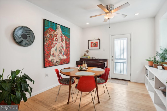 dining space with ceiling fan and light hardwood / wood-style flooring