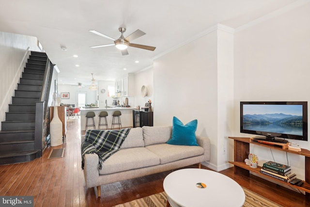 living room featuring ceiling fan, wood-type flooring, and crown molding