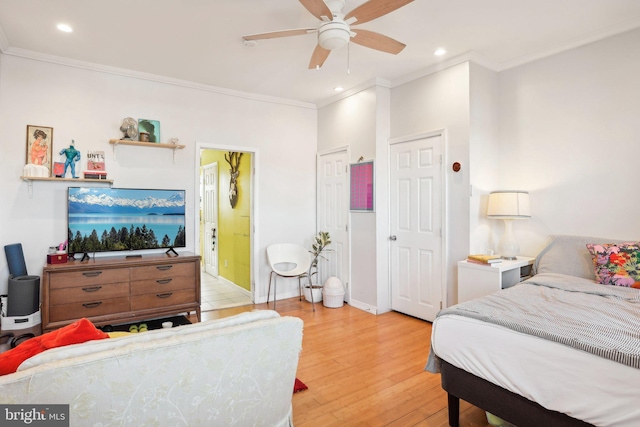 bedroom with connected bathroom, light hardwood / wood-style flooring, ceiling fan, and ornamental molding