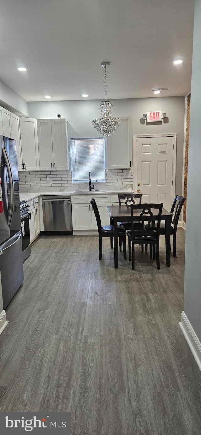 dining room with dark wood-type flooring and an inviting chandelier