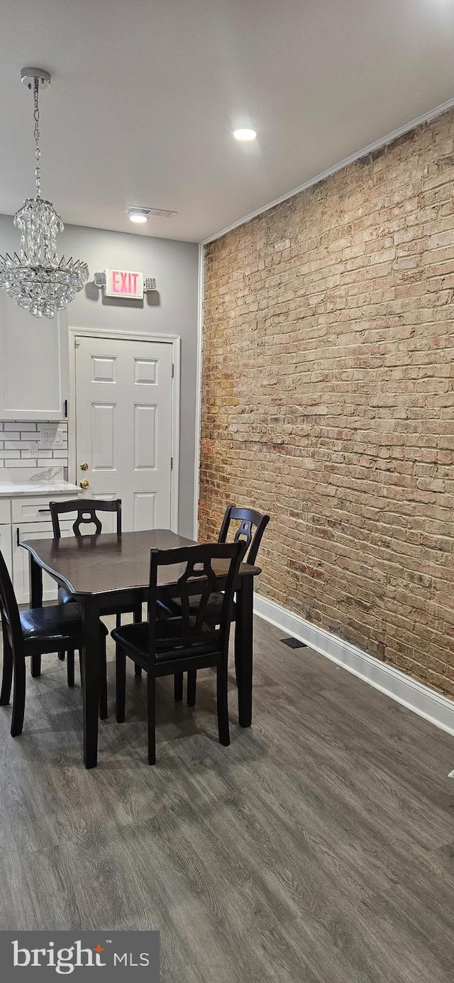 dining area with a chandelier and dark hardwood / wood-style flooring