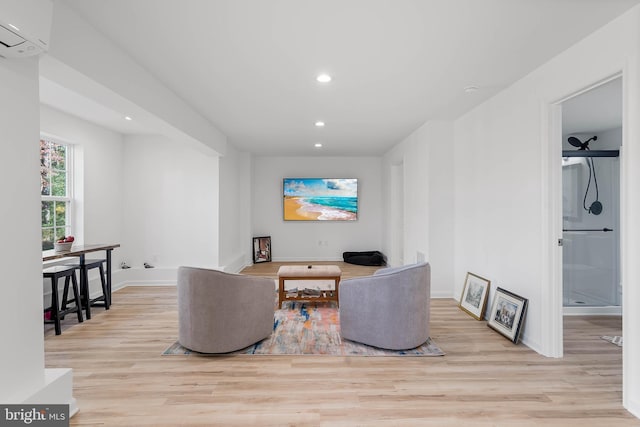 living room with an AC wall unit and light wood-type flooring