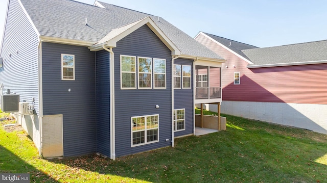 rear view of house with a yard and central air condition unit