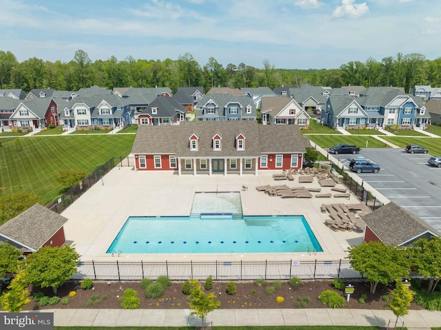 rear view of property with a fenced in pool, a patio area, and a lawn