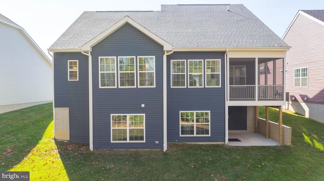 back of property with a patio, a sunroom, and a yard